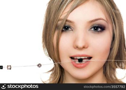 Close-up portrait of beautiful young woman with a bead in her mouth