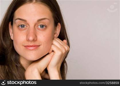 Close-up portrait of beautiful young woman with hands to face.