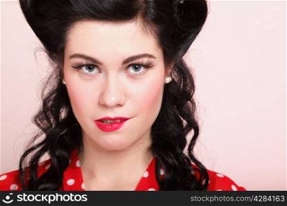 Close up portrait of beautiful young woman with pinup makeup and hairstyle bitting a lip in a sexy expression