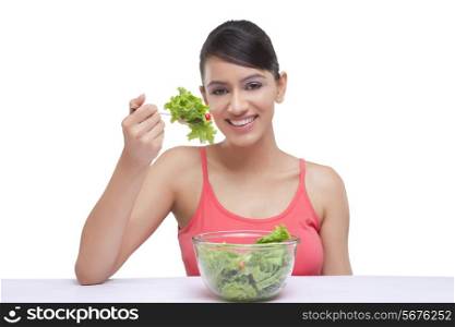 Close-up portrait of beautiful young woman with spinach over white background