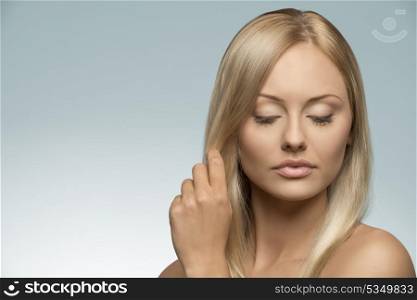 close-up portrait of beauty blonde girl with clean pure skin, natural style, long smooth hair posing with calm expression