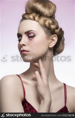 close-up portrait of beauty blonde woman with creative hair-style, red dress and valentines heart shaped make-up. Romantic concept