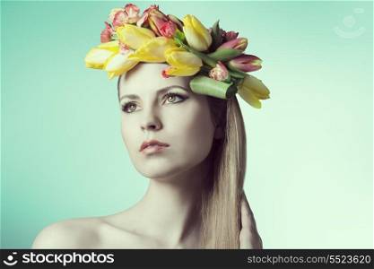 close-up portrait of beauty girl with perfect skin and romantic expression, posing with spring floral garland on her head and colorful make-up