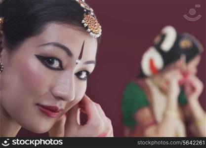 Close-up portrait of Bharatanatyam dancer getting dressed in front of mirror