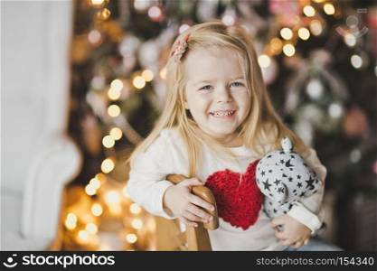 Close-up portrait of blond little girl on the Christmas lights.. Portrait of a child on the Christmas lights 7325.