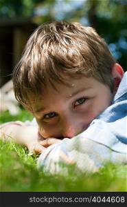 Close up portrait of boy lying in grass