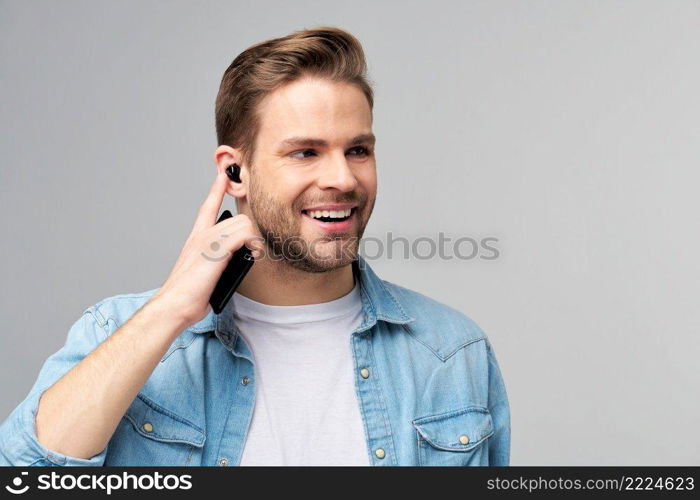 Close up portrait of cheerful young man enjoying listening to music wearing casual jeans outfit.. Close up portrait of cheerful young man enjoying listening to music wearing casual jeans outfit