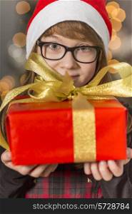 Close-up portrait of cute girl holding wrapped Christmas present