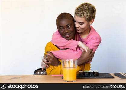 Close up portrait of diverse multiracial happy best friends hugging each other and laughing indoor. Close up lifestyle portrait of diverse multiracial happy best friends hugging each other and laughing indoor