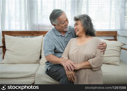 Close-up portrait of elder senior asian attractive lovely kind sweet gentle cheerful cheery peaceful calm spouses hugging holding hands in light white interior room,Portrait of retirement couple.