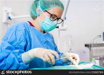 Close-up portrait of female surgeon wearing sterile clothing operating at operating room. High quality photography. Close-up portrait of female surgeon wearing sterile clothing operating at operating room.