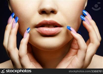 Close-up portrait of girl with blue manicure