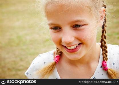 Close up portrait of girl with pigtails looking away smiling