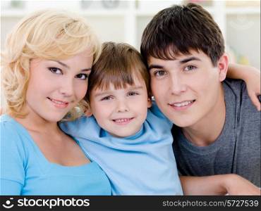 Close-up portrait of happy smiling cheerful family with son - indoors