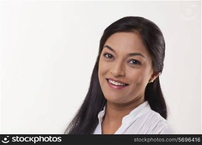 Close-up portrait of mid adult woman smiling over white background
