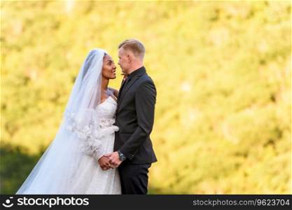 Close-up portrait of newlyweds against brightly lit foliage a. Close-up portrait of newlyweds against brightly lit foliage