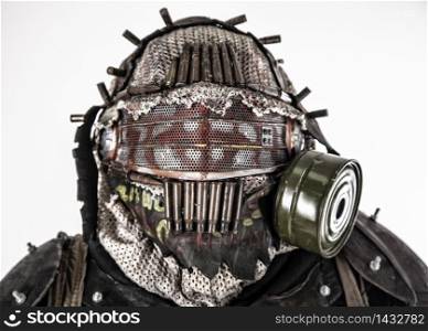 Close up portrait of nuclear post-apocalypse survivor, living underground mutant or creature, skilled stalker wearing rags and armored full-face gas mask or air breathing apparatus, toned shoot. Portrait of post apocalyptic survivor in gas mask