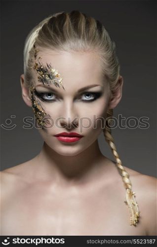 close-up portrait of pretty blonde girl with bride hair-style and creative strong make-up on her visage. Looking in camera