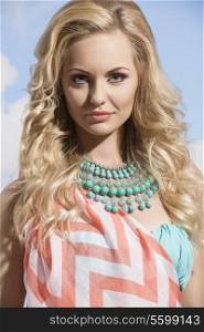 close-up portrait of pretty girl with summer style, blonde hair, pareo and turquoise necklace. woman in vacation