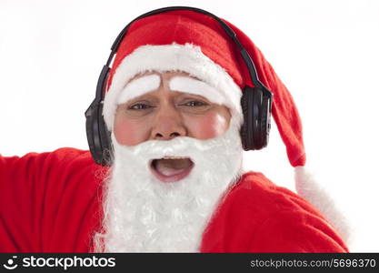 Close up portrait of Santa Claus listening to music over white background