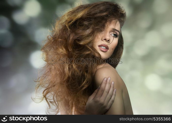 close-up portrait of seductive woman in sensual pose with naked shoulders and crazy bushy hair-style