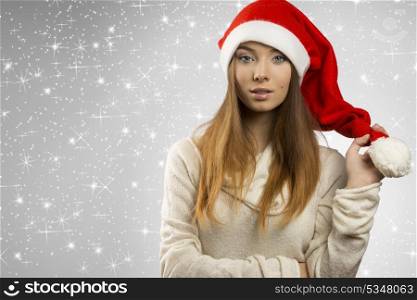 close-up portrait of sensual young girl with long smooth hair and winter christmas style. She wearing wool sweater and funny red santa claus hat