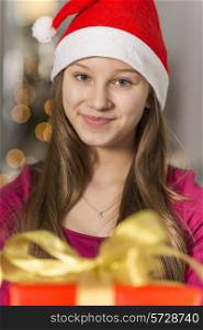 Close-up portrait of smiling girl wearing Santa hat