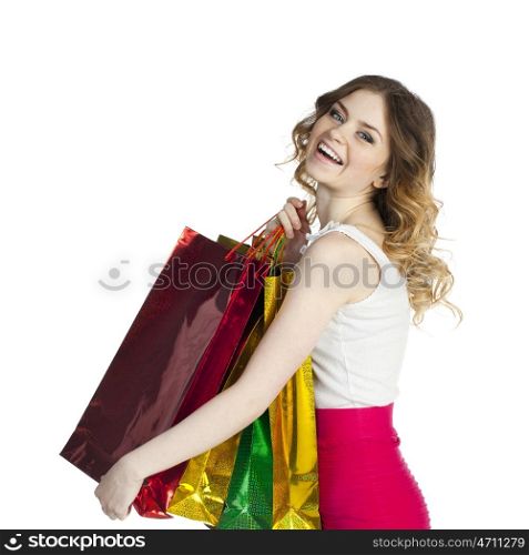 Close up portrait of smiling young blonde girl with colorful shopping bags in white dress posing on a white background