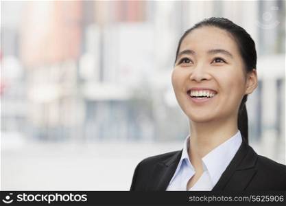 Close-up Portrait of smiling young businesswoman, looking up