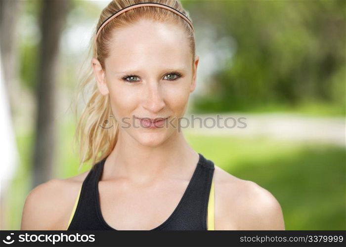 Close-up portrait of smiling young woman against blur background
