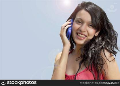 Close-up portrait of smiling young woman with mobile phone