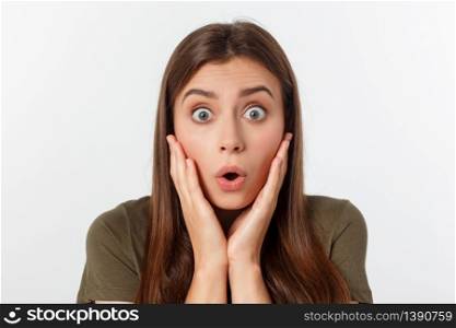 Close-up portrait of surprised beautiful girl holding her head in amazement and open-mouthed. Over white background.. Close-up portrait of surprised beautiful girl holding her head in amazement and open-mouthed. Over white background