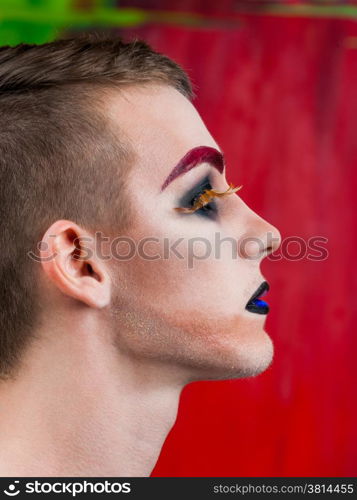 Close-up portrait of the handsome young man fashion model with make-up and big eyelashes