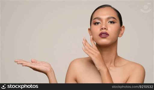 Close up, Portrait of young beautiful female model, smile and showing empty palm for insert and Presentation your product on gray background, beauty and advertising concep