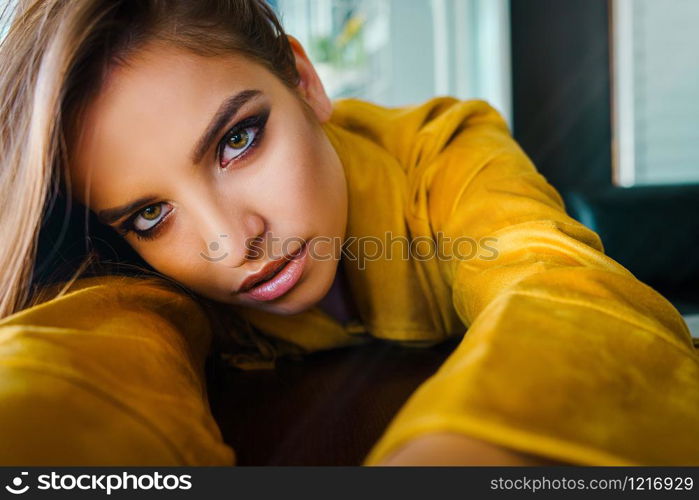 Close up portrait of young beautiful woman leaning on the table looking to the camera model with long hair an beautiful eyes