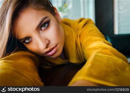 Close up portrait of young beautiful woman leaning on the table looking to the camera model with long hair an beautiful eyes