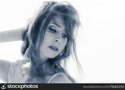 Close up portrait of young beautiful woman outdoor wind waving her hair, tinted black and white image