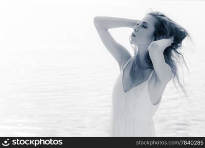 Close up portrait of young beautiful woman outdoor wind waving her hair, tinted black and white image