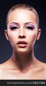 Close-up portrait of young beautiful woman with stylish violet make-up