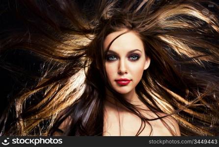 close up portrait of young brunette woman, with her hair in motion