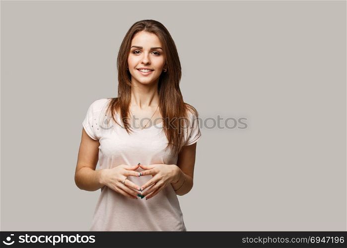 Close up portrait of young cheerful beautiful girl with dark hair in casual shirt smiling and looking in camera.. Close up portrait of young cheerful beautiful girl with dark hair in casual shirt smiling and looking in camera