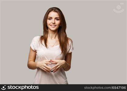 Close up portrait of young cheerful beautiful girl with dark hair in casual shirt smiling and looking in camera.. Close up portrait of young cheerful beautiful girl with dark hair in casual shirt smiling and looking in camera