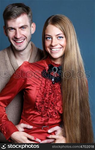 Close up portrait of young couple over dark gray background
