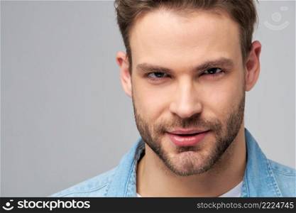 Close-up Portrait of young handsome caucasian man in jeans shirt over light background.. Close-up Portrait of young handsome caucasian man in jeans shirt over light background
