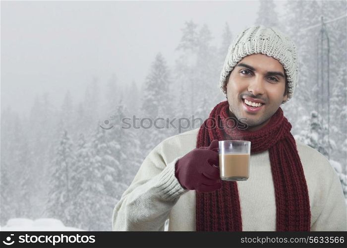 Close-up portrait of young man holding tea cup in winter