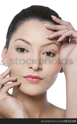 Close-up portrait of young woman touching her face