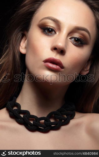 Close-up portrait of young woman with bronze smokey eyes. Modern fashion make-up. Studio shot