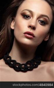 Close-up portrait of young woman with bronze smokey eyes. Modern fashion make-up. Studio shot