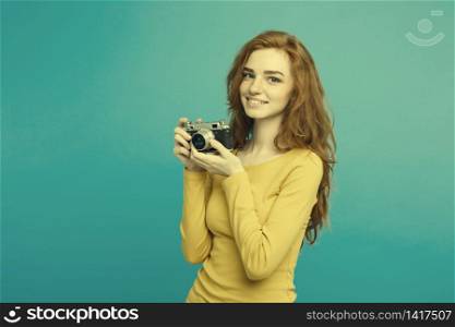 Close up Portrait young beautiful attractive ginger girl happy smiling with vintage camera and ready to travel. Blue Pastel Background. Copy space. Close up Portrait young beautiful attractive ginger girl happy smiling with vintage camera and ready to travel. Blue Pastel Background. Copy space.