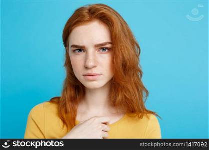 Close up Portrait young beautiful attractive redhair girl feeling nervous looking at camera. Blue Pastel Background. Copy space.